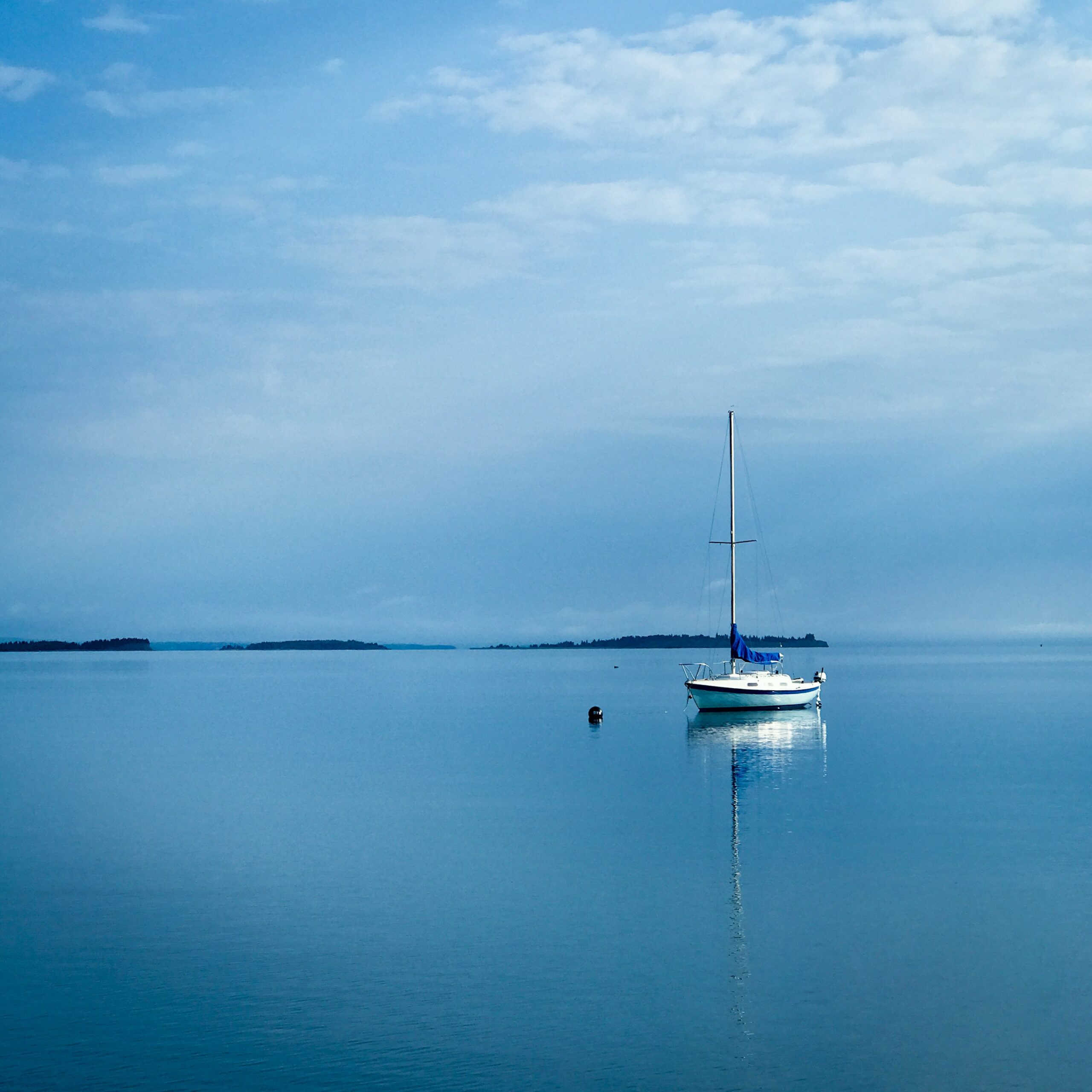 Sailboat floating on calm blue sea