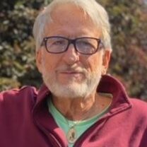 White-haired man with glasses and beard outdoors